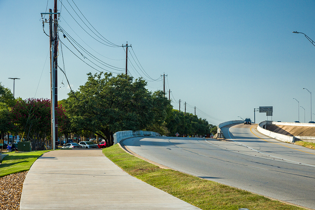 An empty section of the existing shared use path facility on the US 183 Frontage Road.