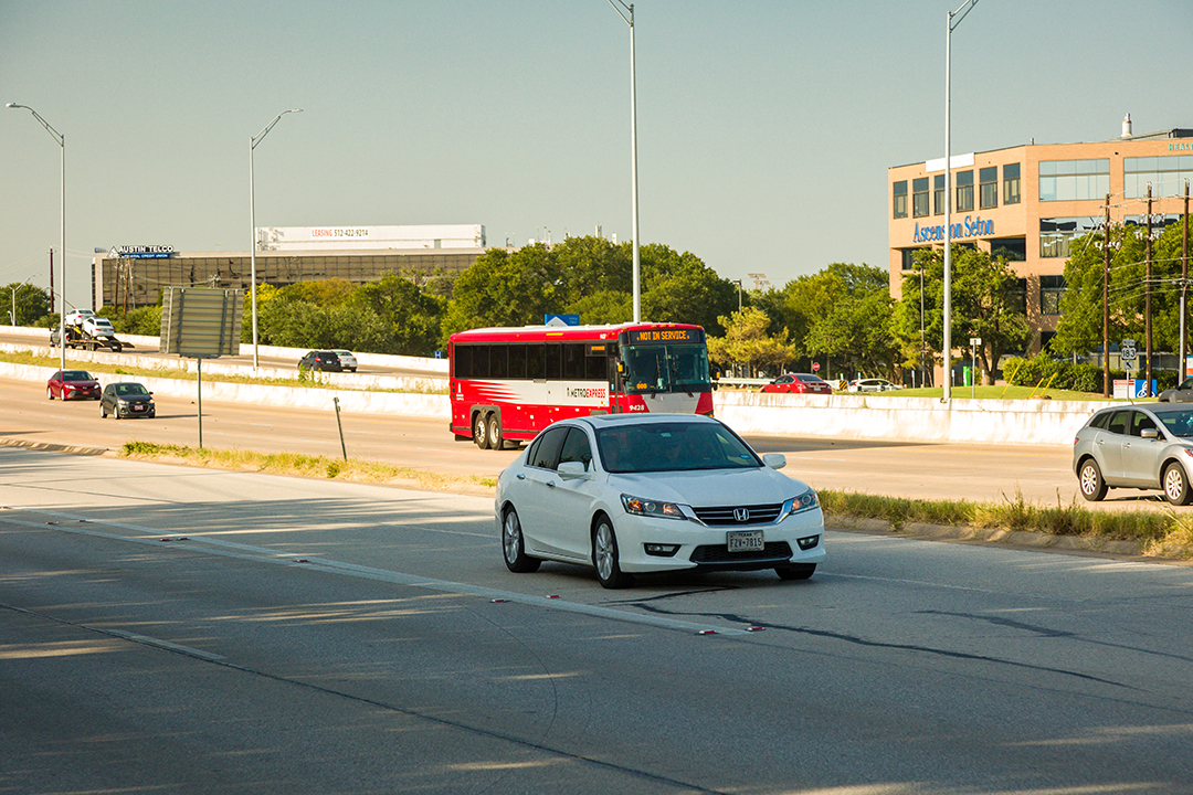 Cars and a red Capital Metro bus traveling southbound on US 183.