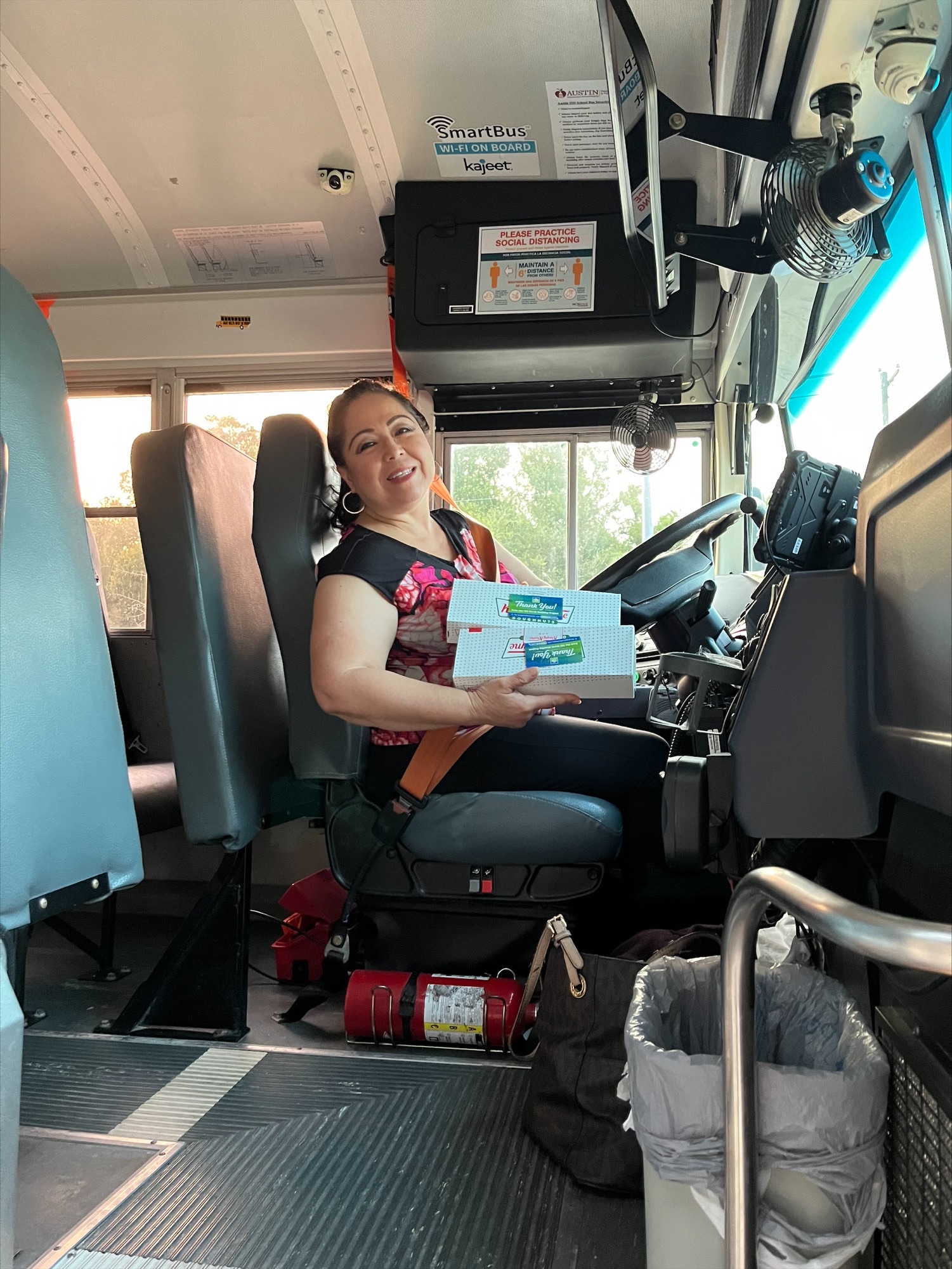 Female bus driver seated at wheel of school bus