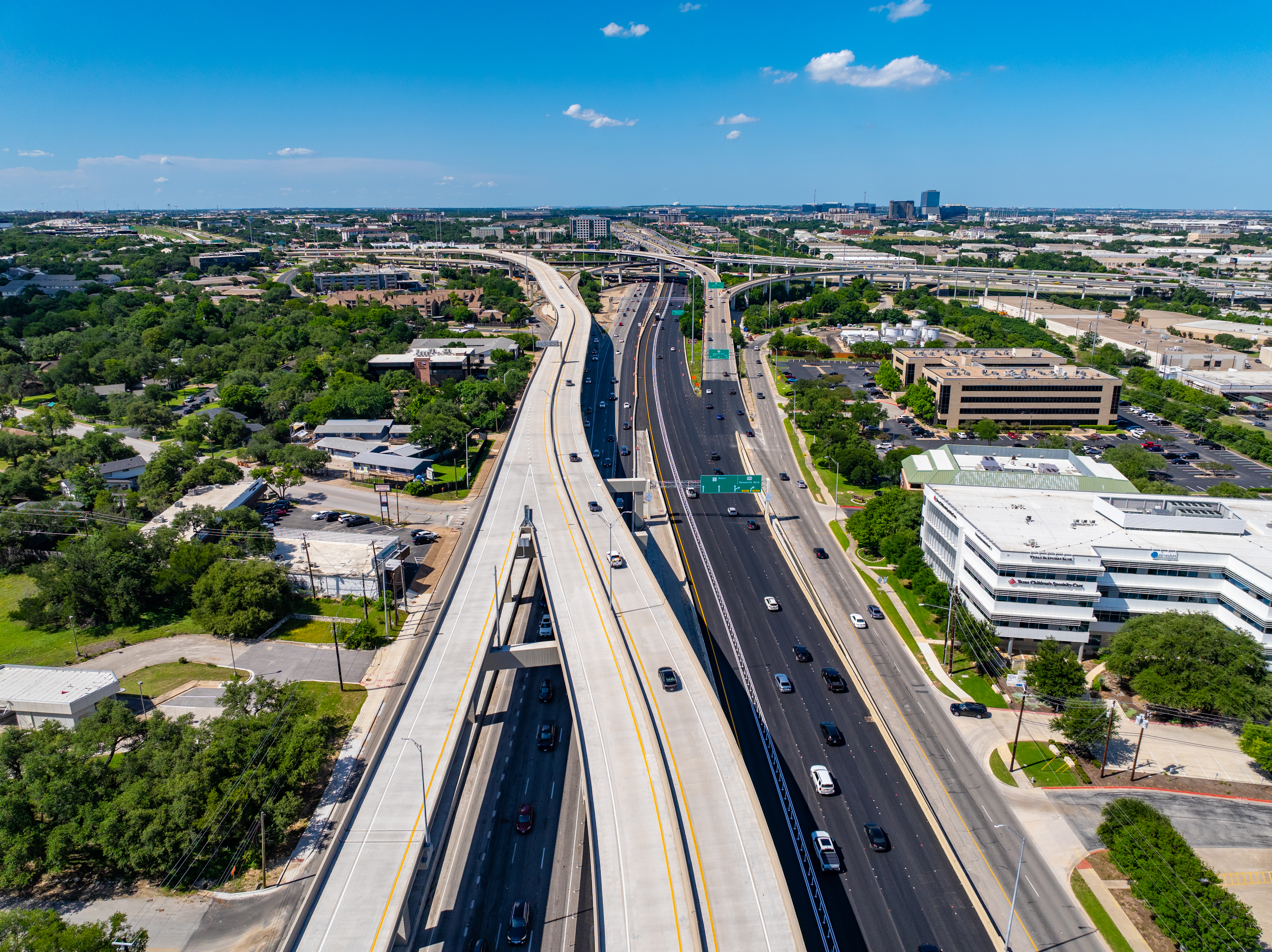 Aerial view of the northbound MoPac Express Lane with Texas Children’s Specialty Care Austin on the right side of the corridor, showing the northbound direct connector bridge from the MoPac Express Lanes to the 183 Express Lanes on the left.