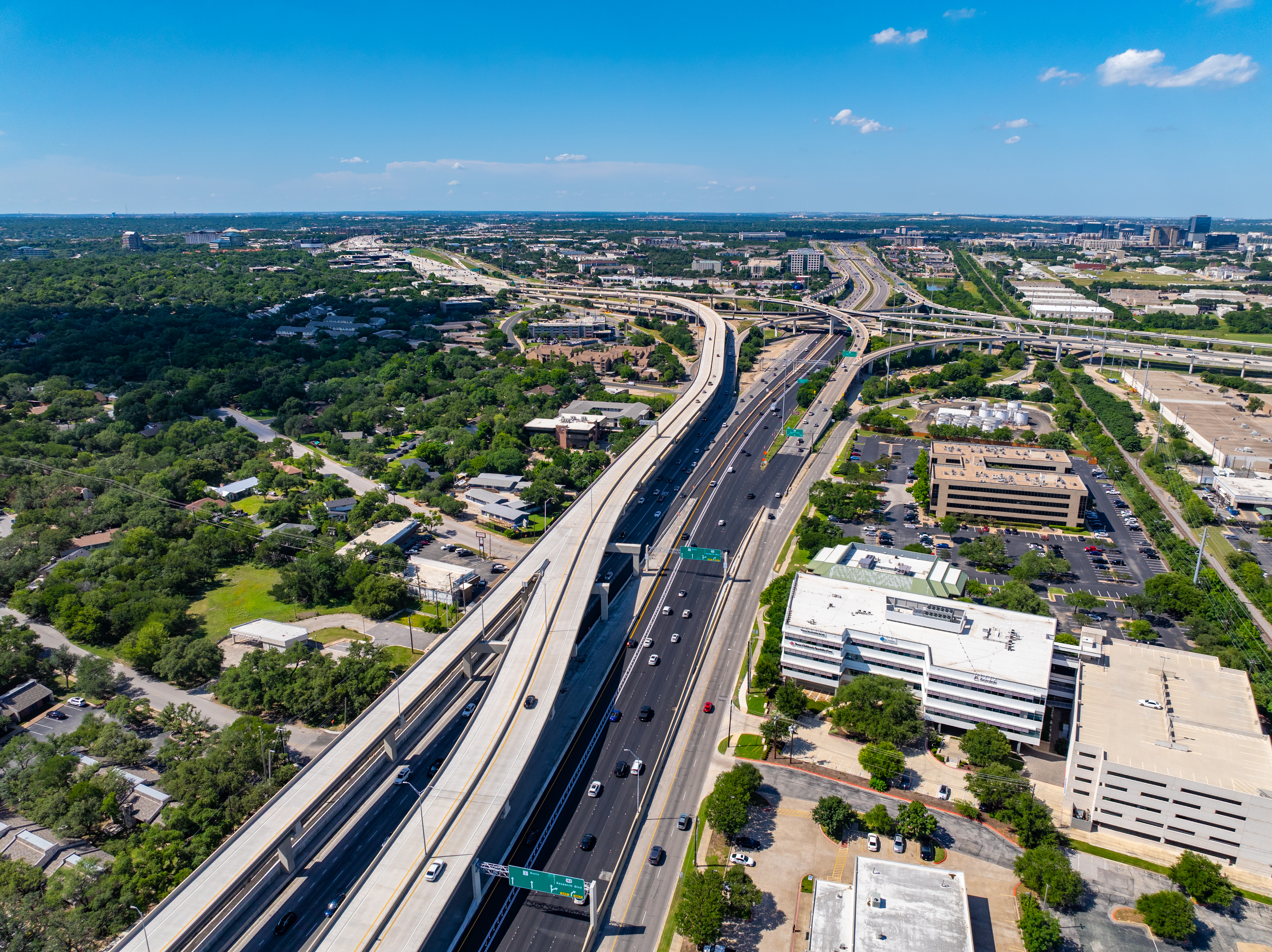 Right-angled aerial view of the northbound MoPac Express Lane with Texas Children’s Specialty Care Austin on the bottom right side of the corridor, showing the northbound direct connection bridge to the 183 Express Lanes in the center of image.