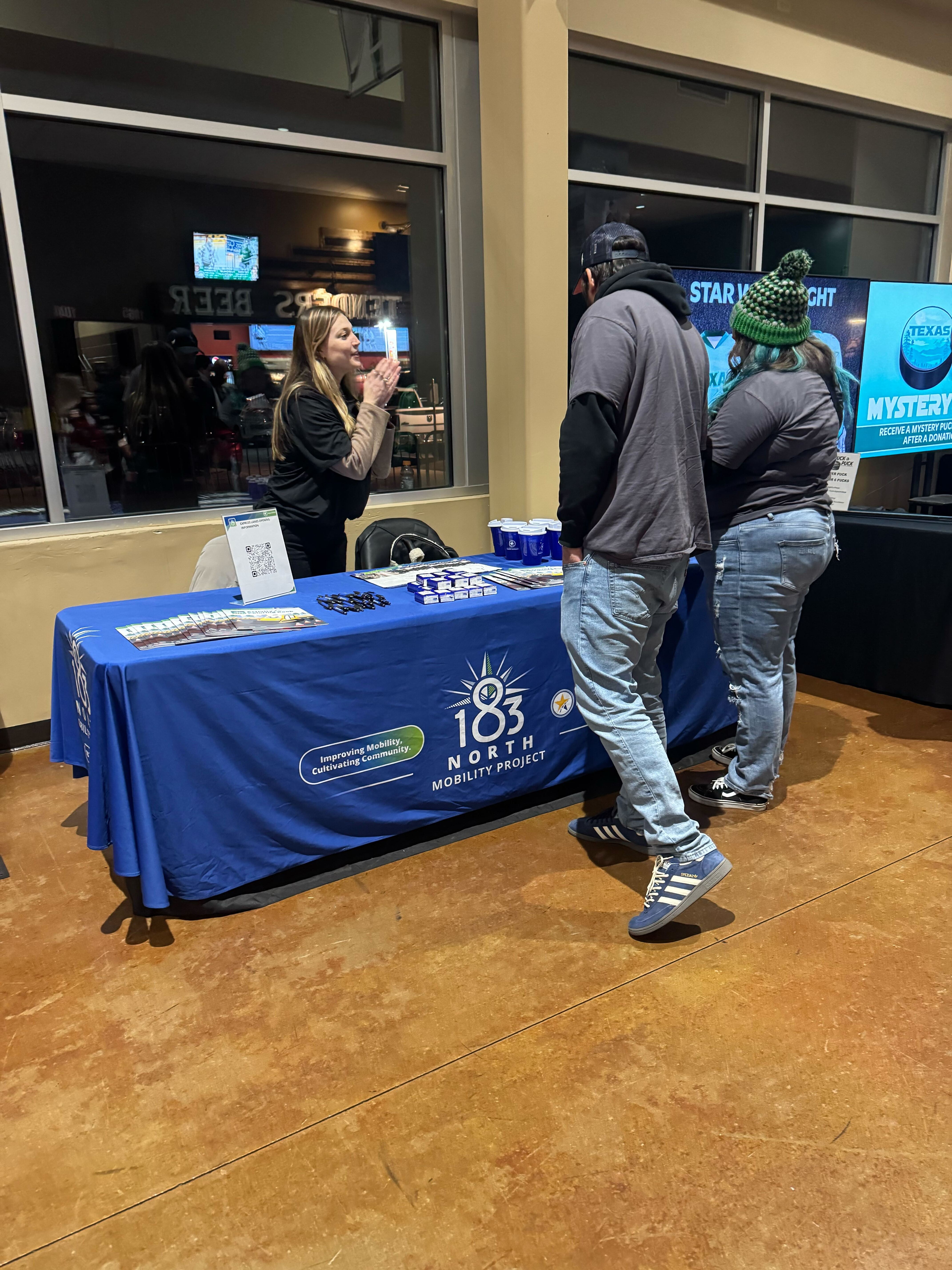 Hockey fans speak to project representative at info table